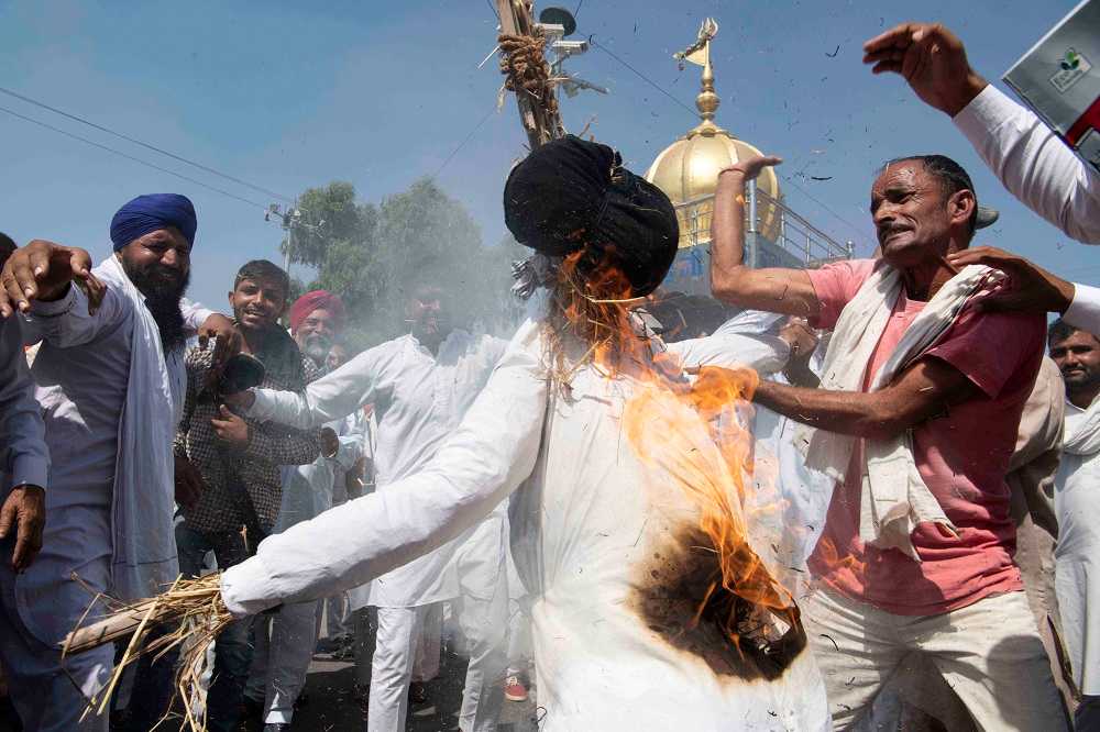 Os protestantes queimam efígies de Narendra Modi, juntamente com os dos bilionários Mukesh Ambani e Gautam Adani. Sirsa, Haryana.